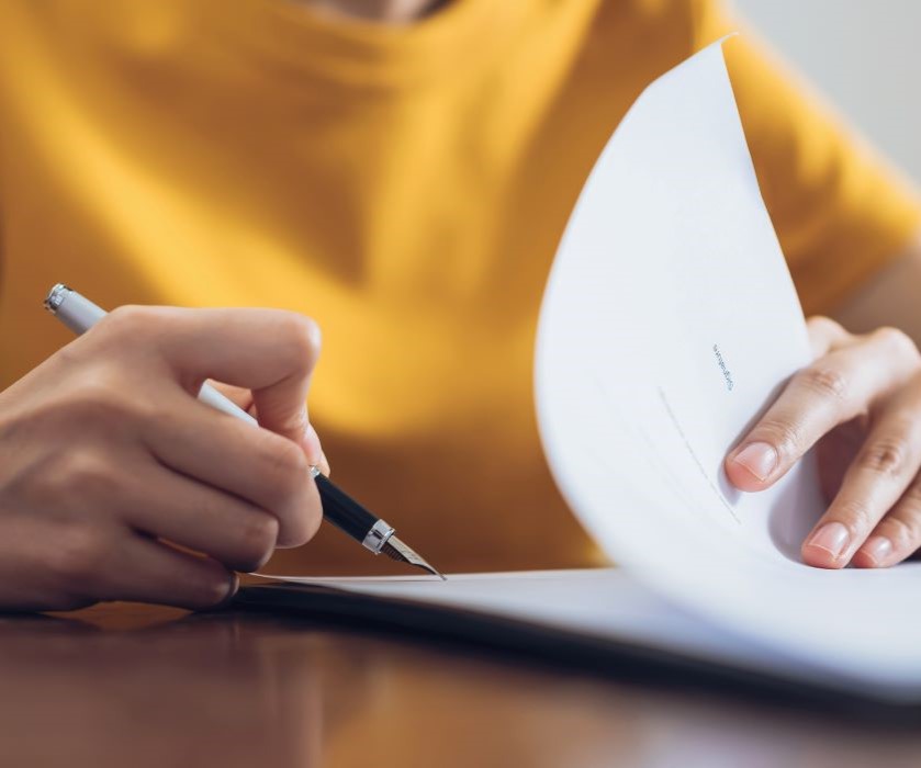 Contrats commerciaux à Marseille. Photographie montrant une personne signant un contrat.