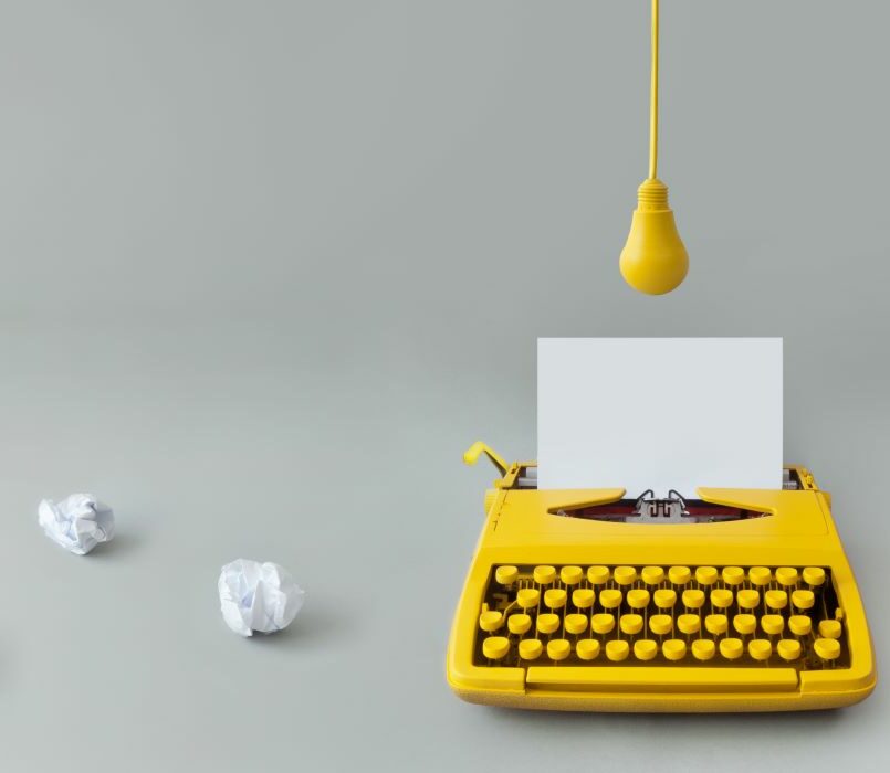 Assistance en droit d'auteur, rédaction de contrats, preuve de création et litiges en contrefaçon par avocat à Marseille. Photographie montrant une machine à écrire et une ampoule jaunes.
